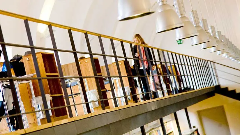 Kvinna på bibliotek. Bilden tillhör Stockholms stads mediaarkiv